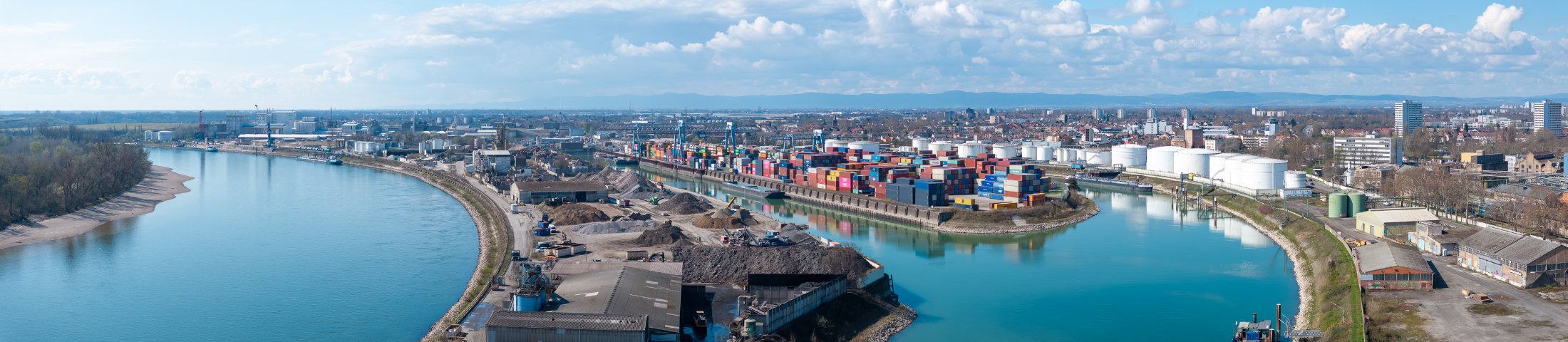 Panorama des Hafens Ludwigshafen am Rhein mit Containerterminal, Kränen, Tanklagern und Industrieanlagen entlang des Rheins.